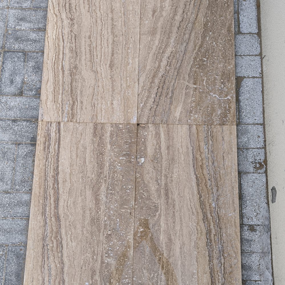 Close-up of Travertine Notcha Light NR showing natural unfilled pores and soft warm walnut and beige tones.