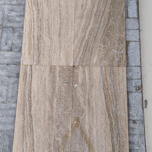 Close-up of Travertine Notcha Light NR showing natural unfilled pores and soft warm walnut and beige tones.
